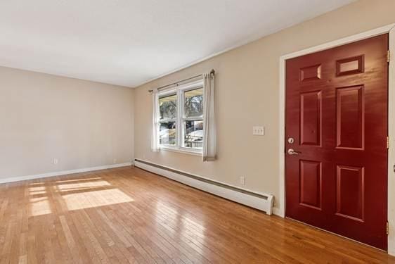 entryway with baseboards, baseboard heating, and hardwood / wood-style flooring