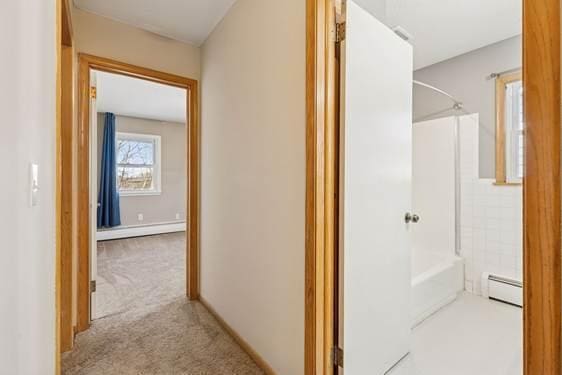 hallway featuring carpet floors, a baseboard radiator, and baseboard heating