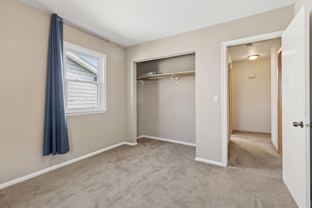 unfurnished bedroom with a closet, carpet flooring, and baseboards