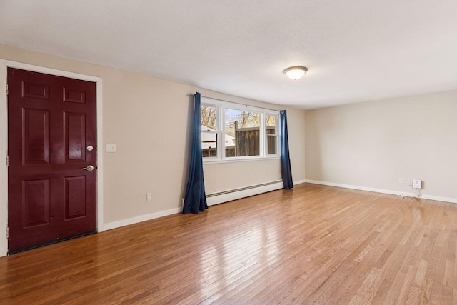 interior space with hardwood / wood-style flooring, baseboards, and a baseboard heating unit