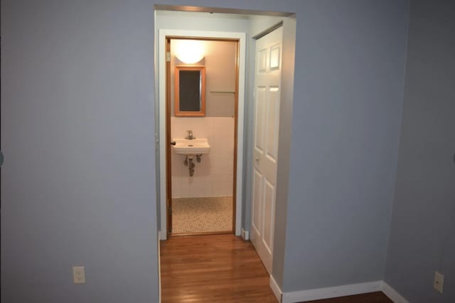 corridor with baseboards and wood finished floors