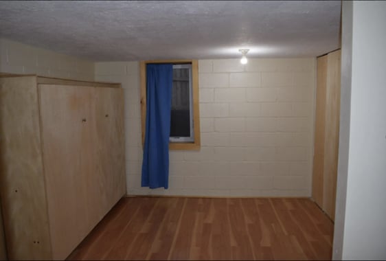 finished below grade area featuring a textured ceiling, wood finished floors, and concrete block wall