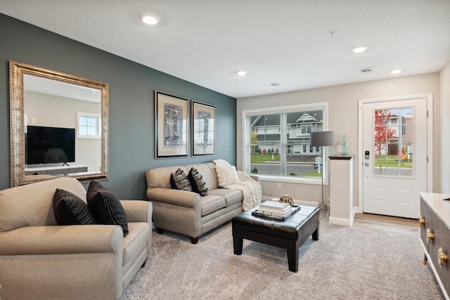 living room featuring light carpet, baseboards, and recessed lighting