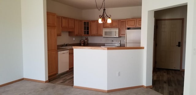 935 Ferndale St N Unit 106, Maplewood, MN 55119 - kitchen featuring glass insert cabinets, light carpet, white appliances, a peninsula, and hanging light fixtures