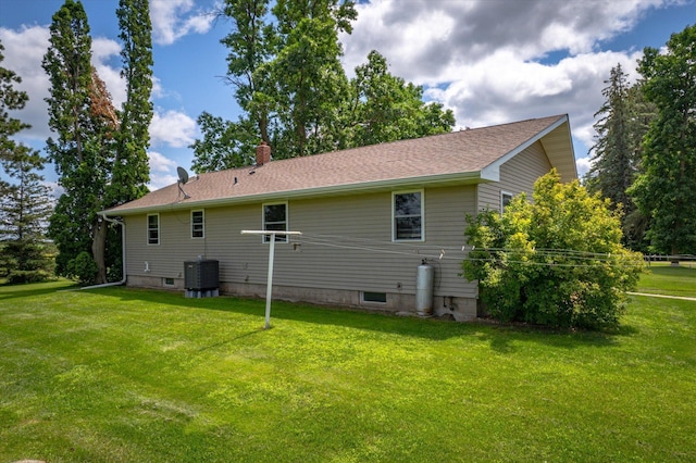 back of property with a lawn, a chimney, and cooling unit