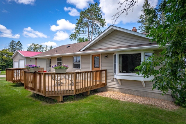 rear view of house with a yard, a chimney, and a wooden deck