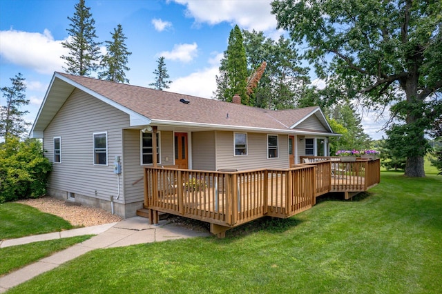 rear view of house featuring a deck, roof with shingles, a lawn, and a chimney