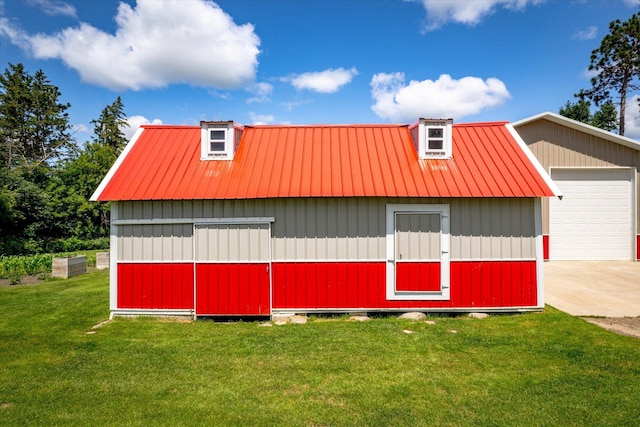 view of side of home with a garage, a yard, metal roof, and an outdoor structure