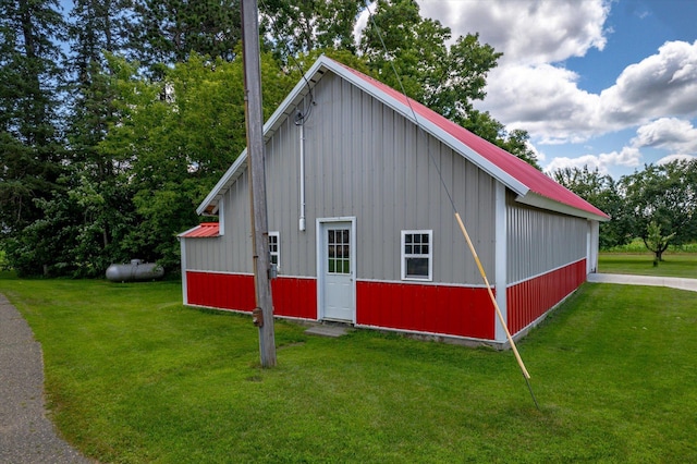 view of side of property featuring metal roof, a yard, and board and batten siding