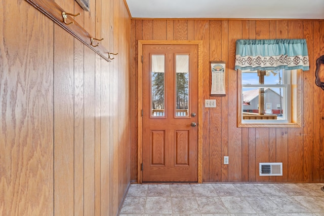 foyer featuring wood walls and visible vents