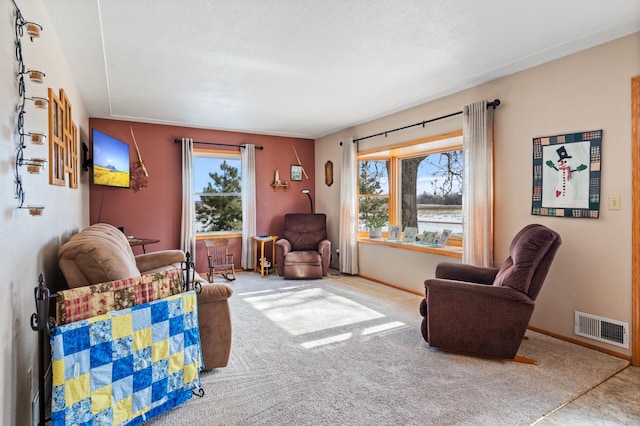 living room featuring carpet, plenty of natural light, visible vents, and baseboards