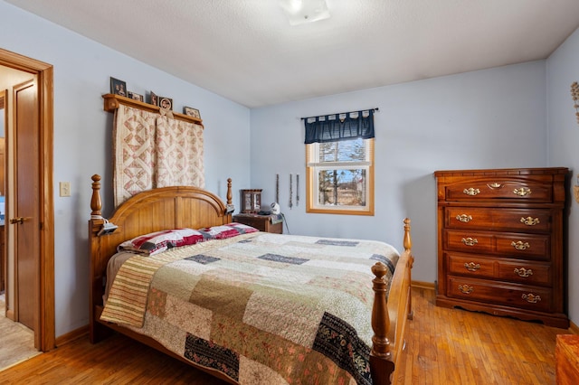 bedroom featuring light wood finished floors and baseboards