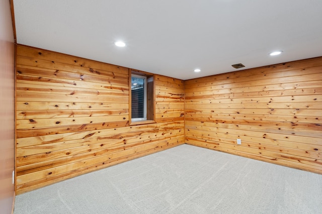 spare room featuring wooden walls, carpet flooring, and recessed lighting