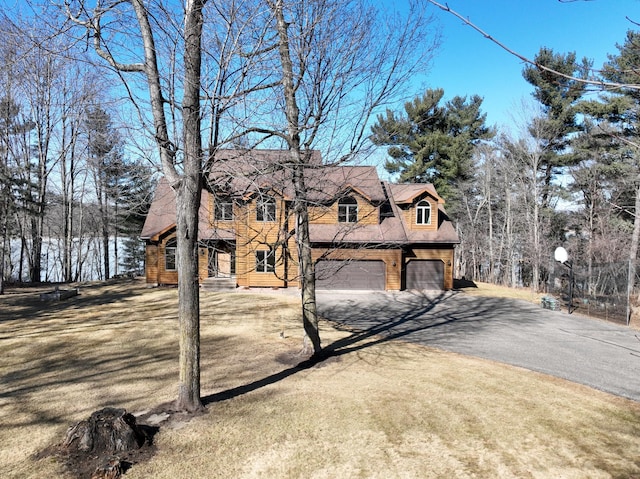 view of property exterior with aphalt driveway and an attached garage