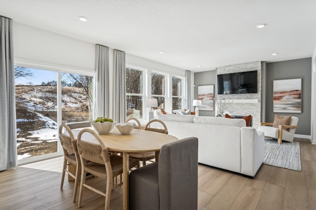 dining space with recessed lighting, a fireplace, light wood-style flooring, and baseboards