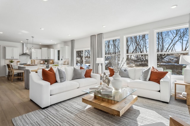 living room with light wood-type flooring, baseboards, and recessed lighting