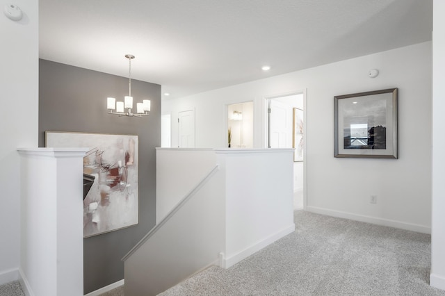 hall featuring recessed lighting, carpet flooring, an upstairs landing, baseboards, and an inviting chandelier