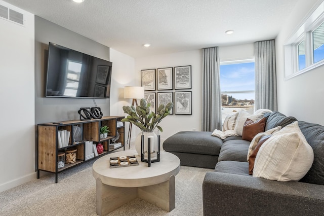 carpeted living area featuring recessed lighting, visible vents, a textured ceiling, and baseboards