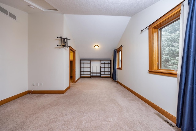 spare room featuring light carpet, visible vents, and baseboards