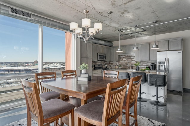 dining space featuring visible vents and an inviting chandelier