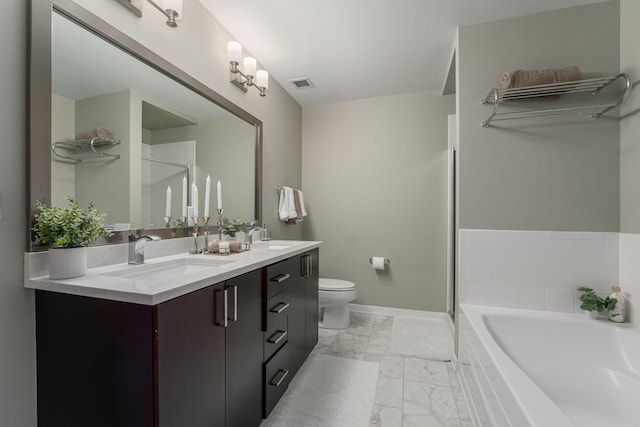 bathroom with visible vents, toilet, marble finish floor, a garden tub, and a sink