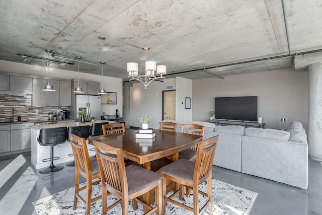 dining space featuring a notable chandelier and concrete flooring