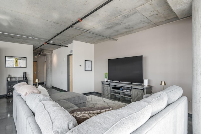 living room with concrete flooring and baseboards