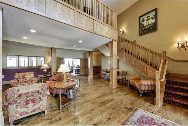 living room with hardwood / wood-style flooring, stairway, decorative columns, and recessed lighting