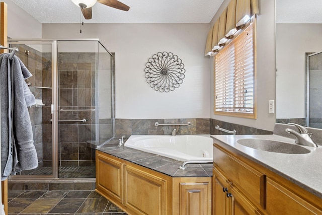 full bathroom with a textured ceiling, a stall shower, vanity, and a garden tub