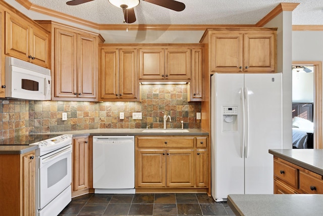 kitchen with stone finish flooring, decorative backsplash, white appliances, a textured ceiling, and a sink