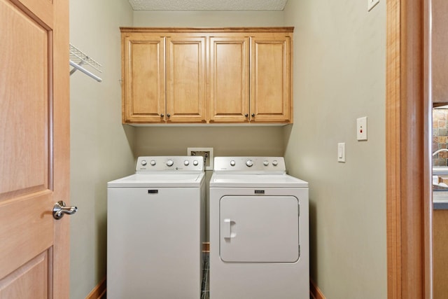 clothes washing area featuring cabinet space and washing machine and clothes dryer