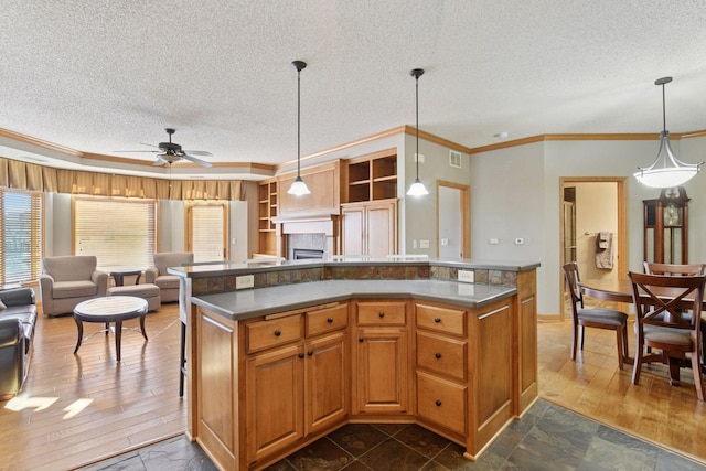 kitchen featuring visible vents, dark wood-type flooring, a textured ceiling, open floor plan, and crown molding