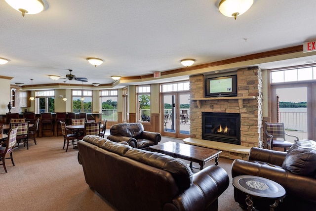 living area with a stone fireplace, french doors, and light carpet