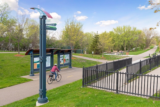 view of property's community featuring fence and a lawn