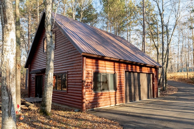 exterior space with metal roof and a garage