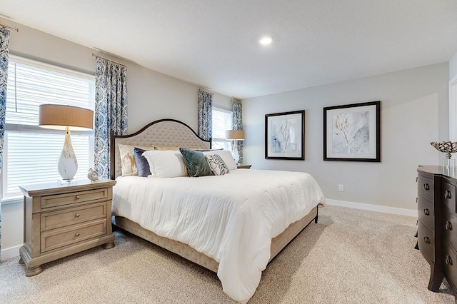 bedroom featuring light carpet and baseboards