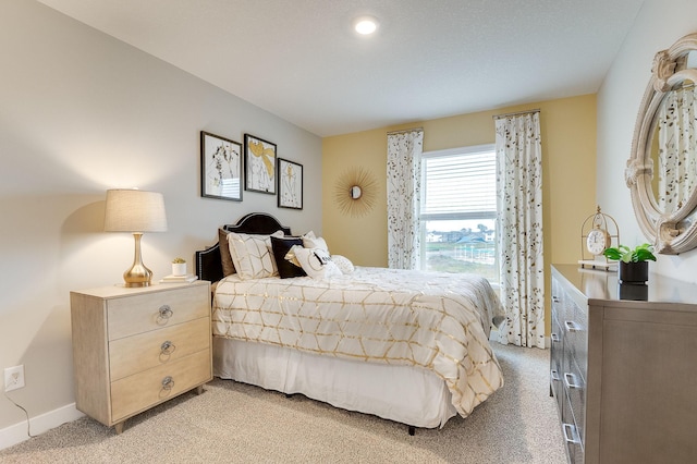 bedroom featuring light carpet and baseboards