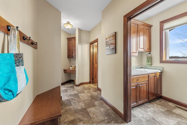 hall featuring a sink, visible vents, and baseboards