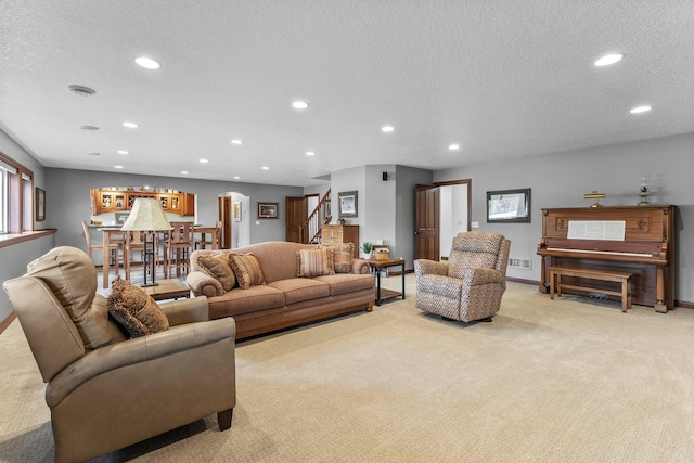 living room featuring recessed lighting, stairway, light carpet, and a textured ceiling