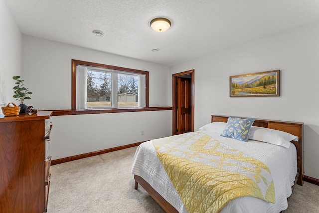 bedroom with carpet, baseboards, and a textured ceiling