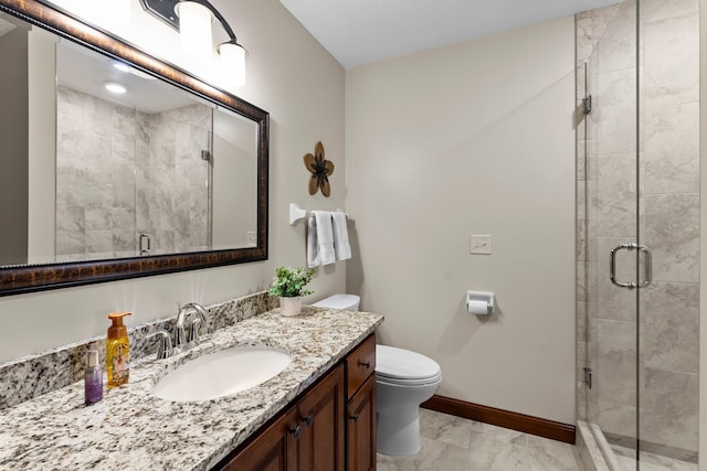 bathroom with a shower stall, baseboards, toilet, marble finish floor, and vanity