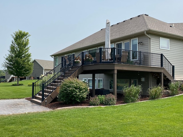 rear view of property with stairway, a wooden deck, a shingled roof, a chimney, and a lawn