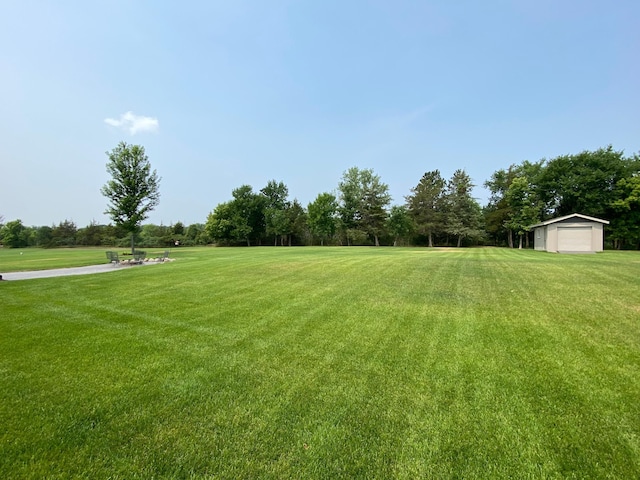 view of yard featuring a garage and an outdoor structure