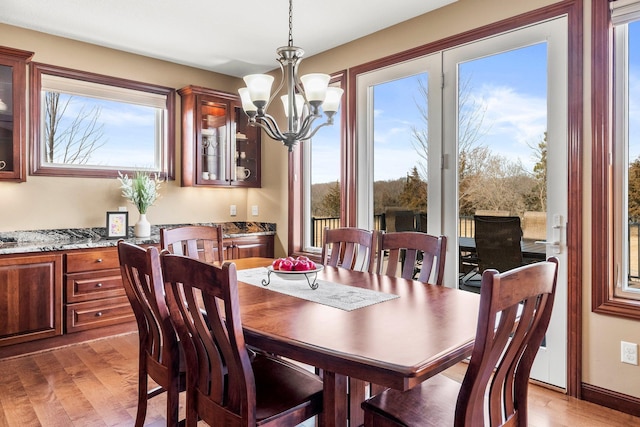 dining area featuring light wood-type flooring and a notable chandelier