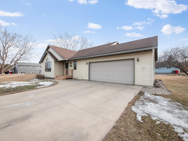 ranch-style house with driveway, a garage, and roof with shingles