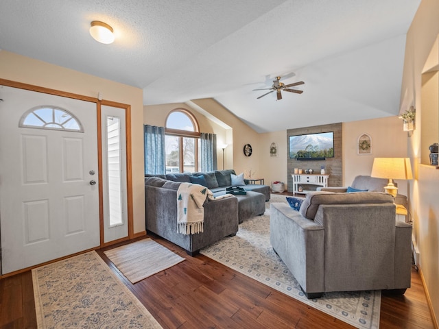 interior space with ceiling fan, a textured ceiling, dark wood-style floors, and vaulted ceiling