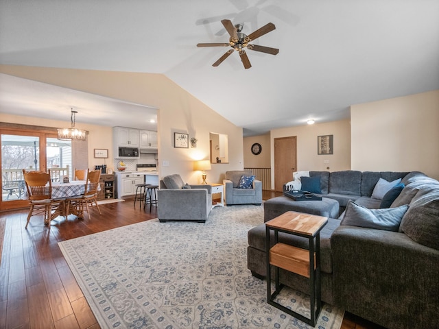 living area with hardwood / wood-style floors, lofted ceiling, and ceiling fan with notable chandelier