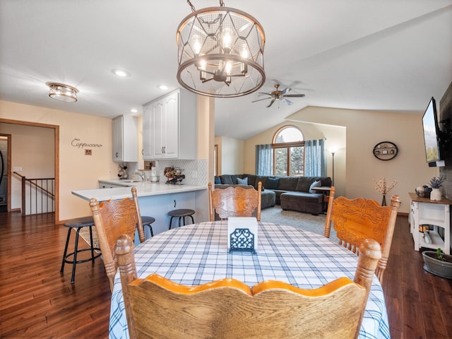 dining room featuring ceiling fan with notable chandelier, lofted ceiling, recessed lighting, and dark wood-style floors