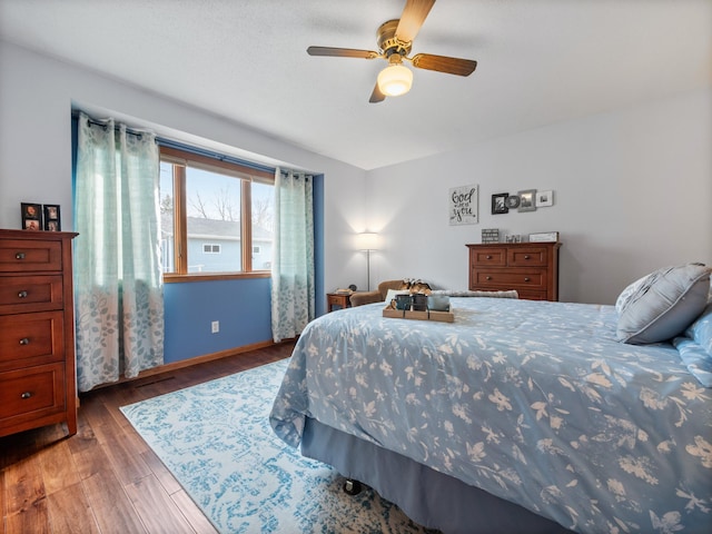 bedroom with baseboards, ceiling fan, and wood finished floors