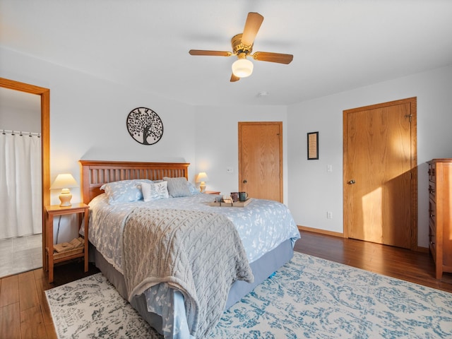 bedroom featuring hardwood / wood-style floors, a ceiling fan, and baseboards